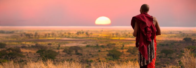 Masai man on Serengeti at sunset, Tanzania